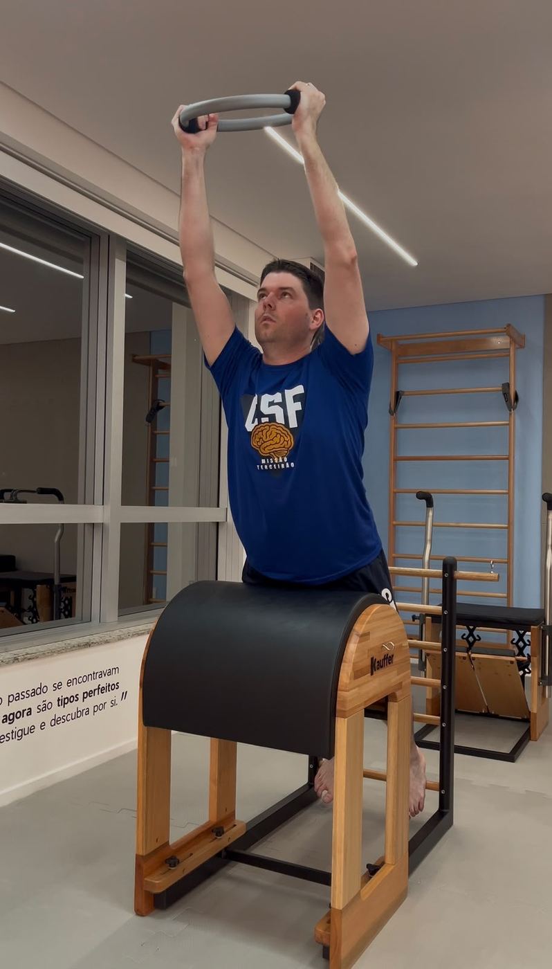 Aluno com anel de pilates no Barrel